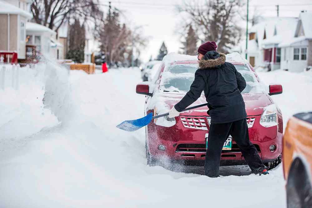 MIKAELA MACKENZIE / WINNIPEG FREE PRESS
Nicholas McGoldrick clears the way for his car in the West End.