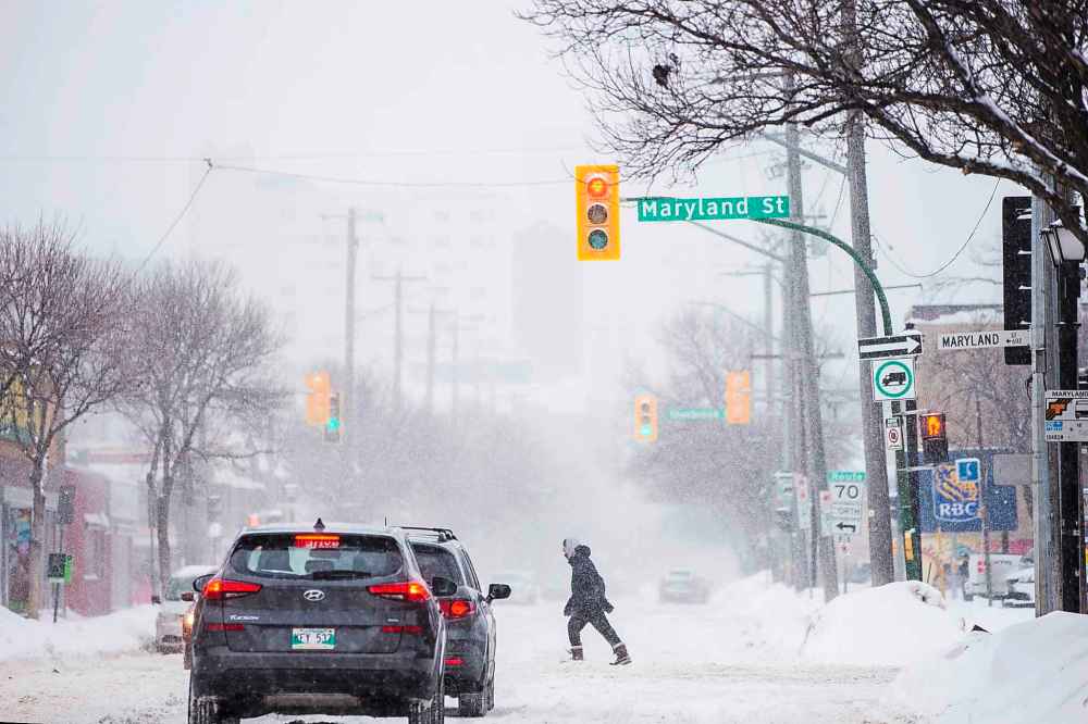 MIKAELA MACKENZIE / WINNIPEG FREE PRESS
Folks brave the snow while crossing Sargent Avenue Tuesday morning.