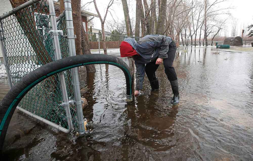 Brett Hanslit continues inspecting his property by checking on anothert pump. (John Woods / Winnipeg Free Press)