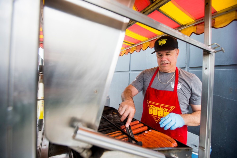 MIKAELA MACKENZIE / WINNIPEG FREE PRESS
Darren Yewchyn, owner of Smoke’n Bob’s Hot Dogs, runs the grill at his hot dog cart in Winnipeg.
