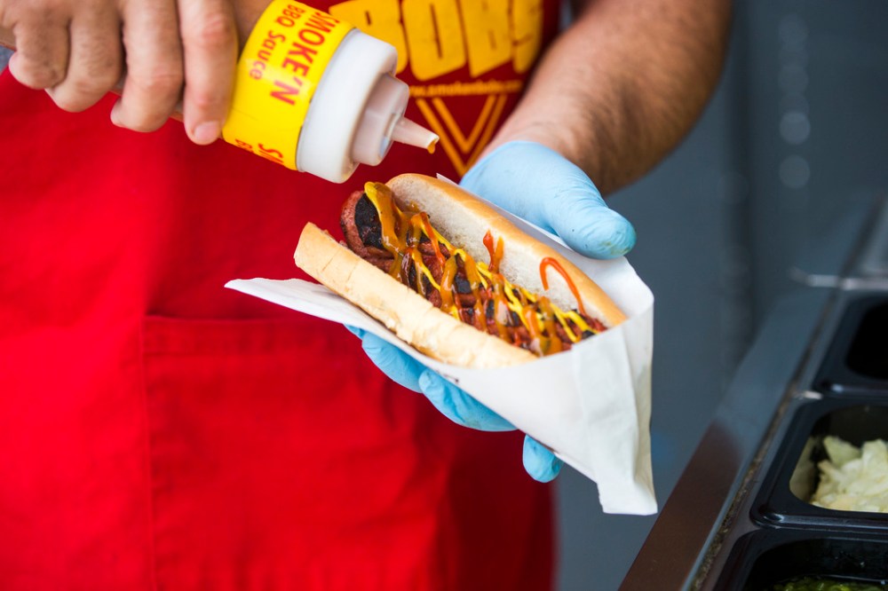 MIKAELA MACKENZIE / WINNIPEG FREE PRESS
Darren Yewchyn, owner of Smoke’n Bob’s Hot Dogs, puts toppings onto a smokie in Winnipeg.