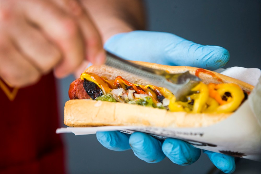 MIKAELA MACKENZIE / WINNIPEG FREE PRESS



Darren Yewchyn, owner of Smoke’n Bob’s Hot Dogs, puts toppings onto a smokie in Winnipeg on Monday, June 13, 2022.  For Dave Sanderson story.

Winnipeg Free Press 2022.