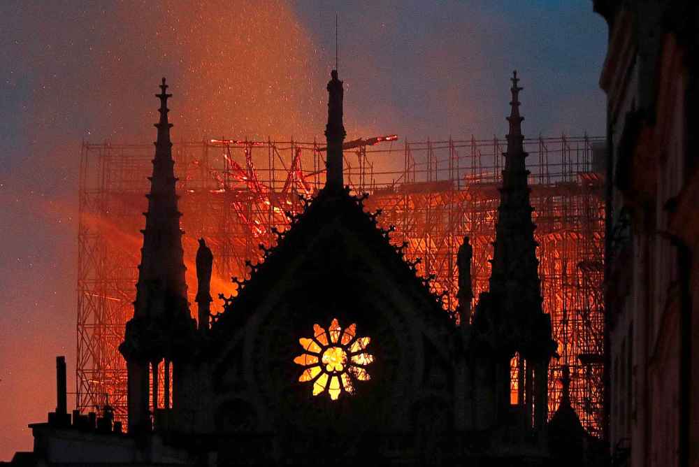 Flames and smoke rise from Notre Dame cathedral as it burns (Thibault Camus / The Associated Press)
