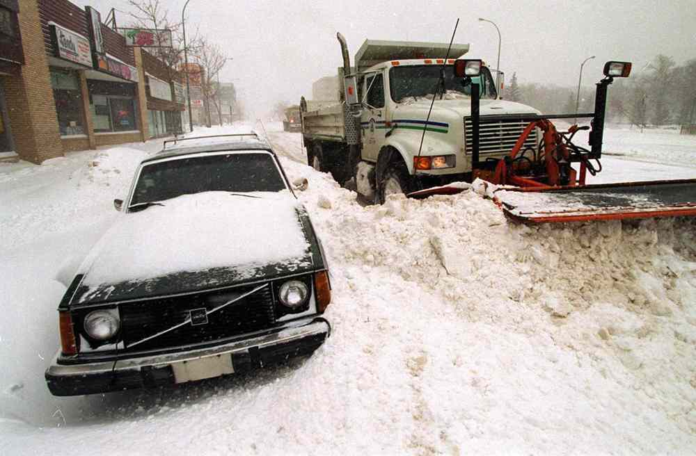 A City of Winnipeg snowplow works around vehicles on Portage Avenue on Sunday, April 6. The city had come to a virtual standstill. (Jeff DeBooy / Winnipeg Free Press files)