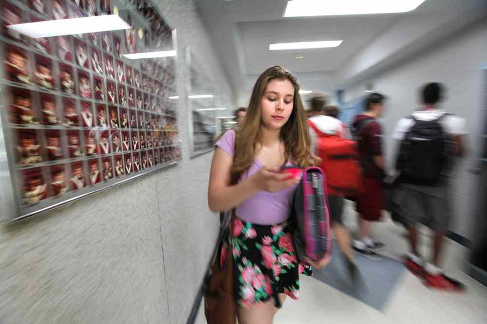 Grade 9: Mackenzie makes her way through a crowded hallway between classes while texting on her phone. (Ruth Bonneville / Winnipeg Free Press)