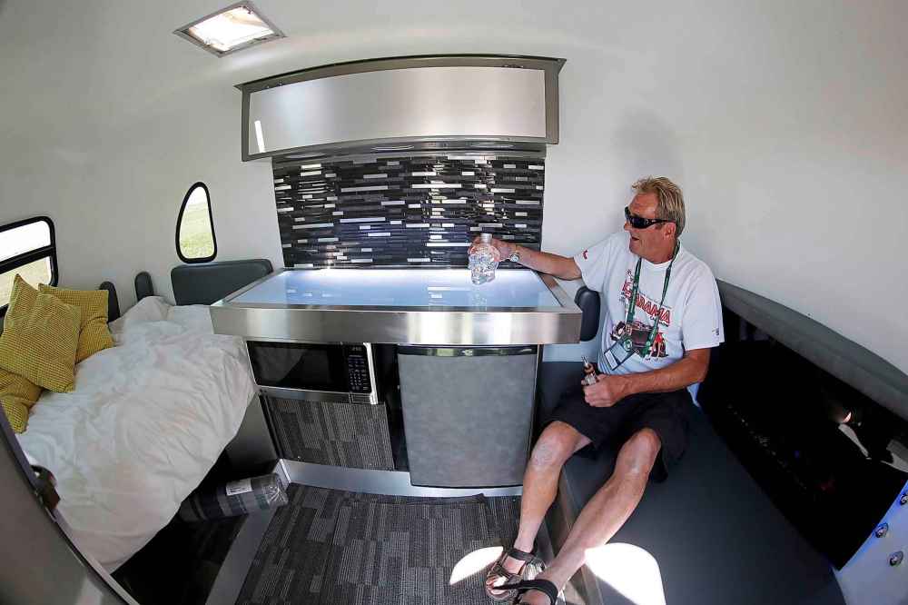 Schellenberg shows off the modern interior in his yellow school bus themed trailer.