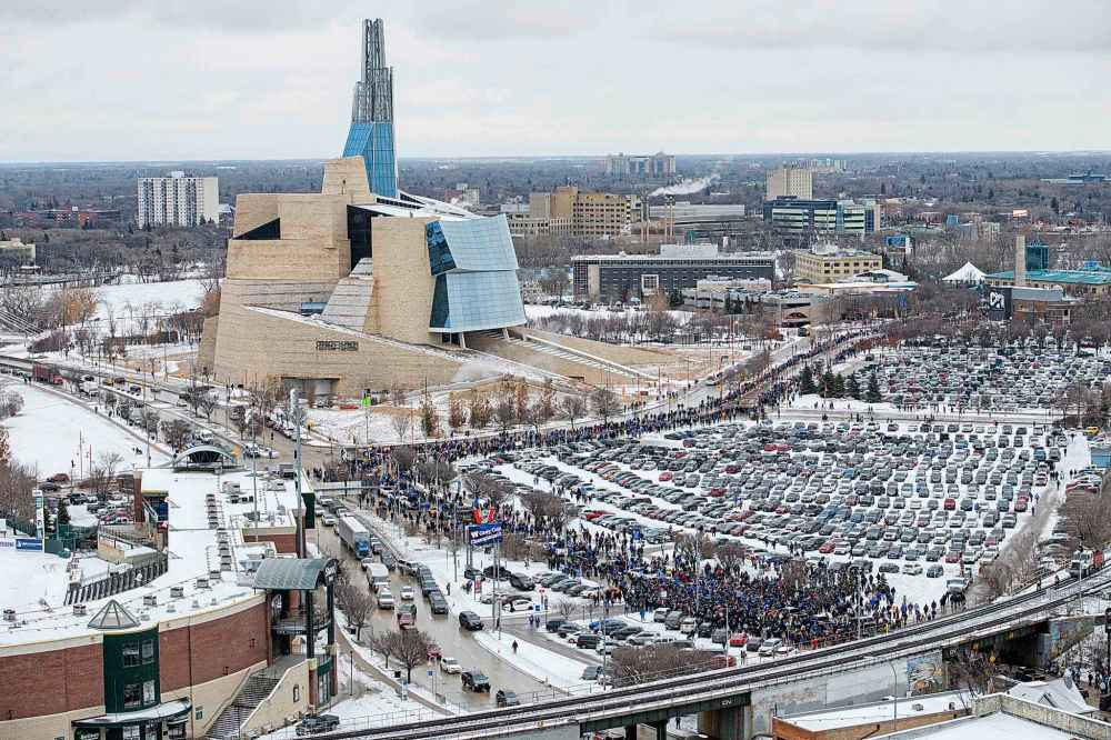 Hundreds of Winnipeggers walk past the Goldeyes Stadium Tuesday afternoon as they cheer on their Winnipeg Blue Bombers Grey Cup Champions after parading through Portage Ave and Main St. (Mike Sudoma / Winnipeg Free Press)