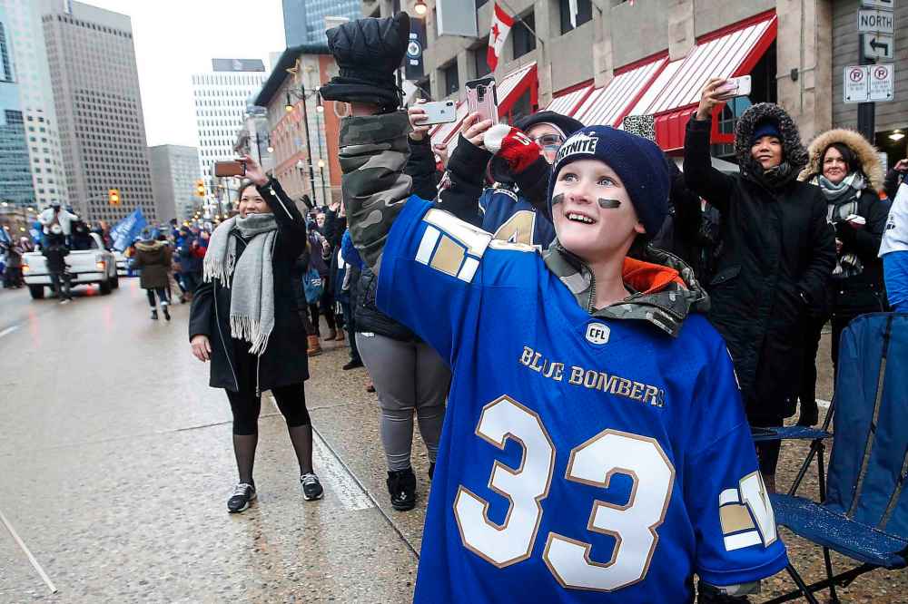 Crowds cheer as the team goes by on floats. (John Woods / The Canadian Press)