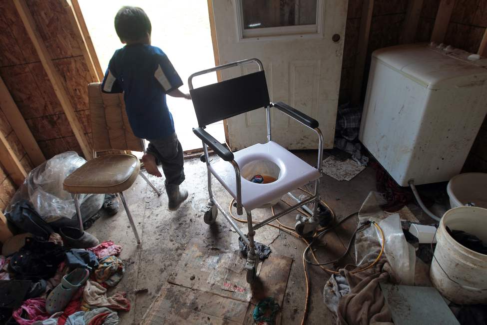 JOE BRYKSA/WINNIPEG FREE PRESS
A child runs past a makeshift toilet in elder Moyer Taylor's porch in this July 2010 photo on Garden Hill, First Nation. Thousands of Manitoba residents an hour flight from Winnipeg have no running water in their homes, putting them at increased risk for a host of health problems usually associated with the world's poorest countries.