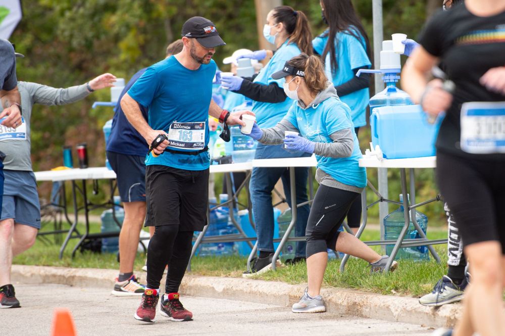 MIKE SUDOMA / Winnipeg Free Press
Manitoba Marathon volunteers wearing masks and gloves hand out water to runners as they take part in the Manitoba Marathon Sunday morning.
