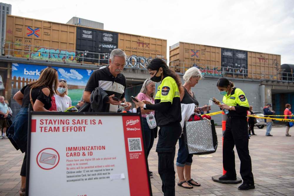 Concert goers line up to have their proof of vaccination scanned before entering Shaw Park for the concert. (Alex Lupul / Winnipeg Free Press)