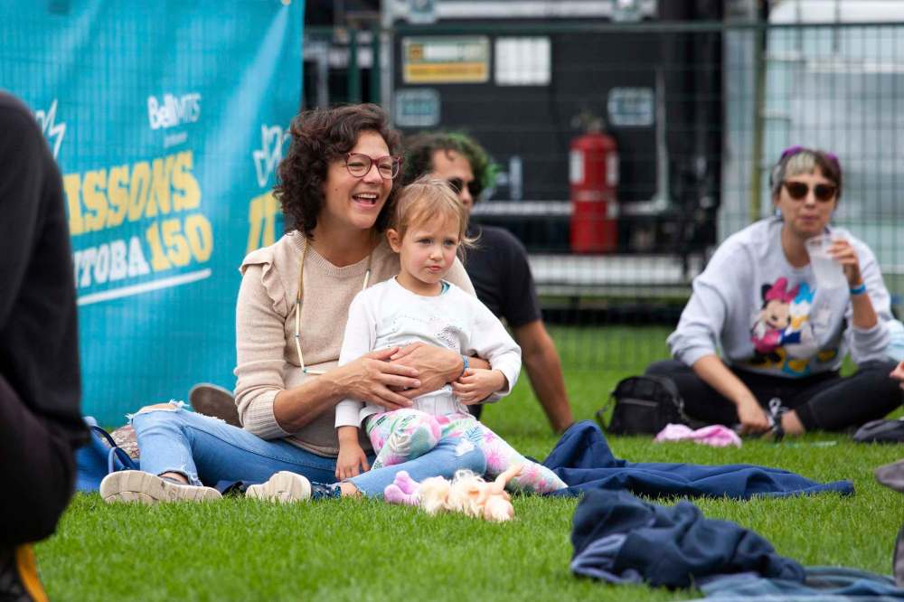 Ruby Kuipers holds her four-year-old daughter, Grace, as they watch William Prince perform. (Daniel Crump / Winnipeg Free Press)