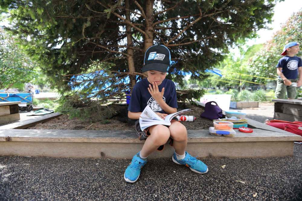 Leif reads his comic book in the shade during lunch break.