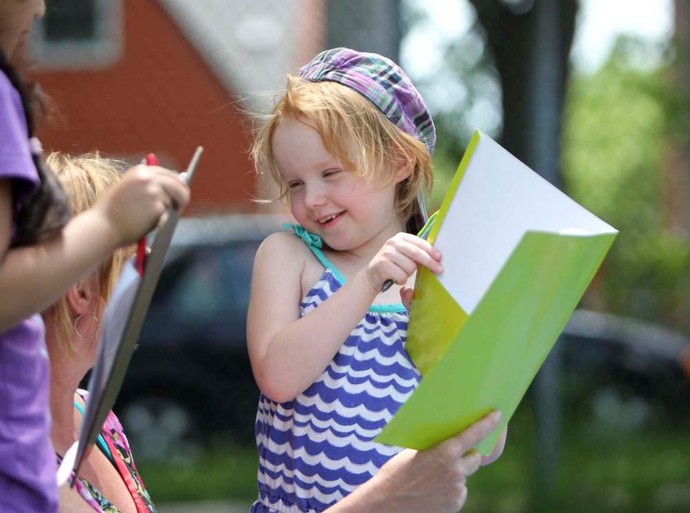 Amalia is all smiles showing her teacher her work.