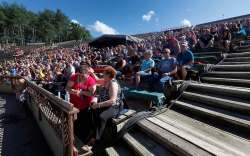 A pair of early birds saving a front row seat apply the sun block as the main stage crowd starts to arrive.