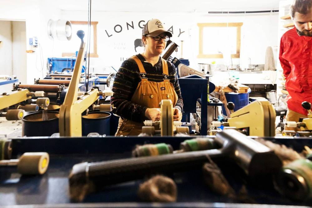 Hunter sets up the spinner, which is where roving fibre is transformed into spun yarn.They can spin 12 spindles at a time and can do a variety of yarn weights. (Prabhjot Singh Lotey / Winnipeg Free Press)