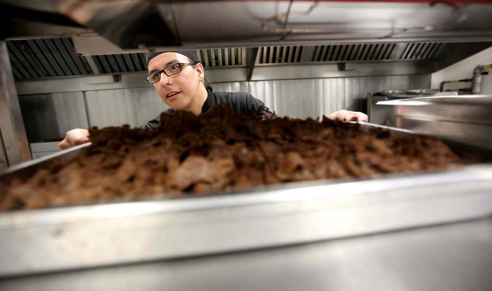 Kale Manoakeesock, lead cook at Shaw Park, prepares the after-game meal for players from both teams and the umpiring crew.