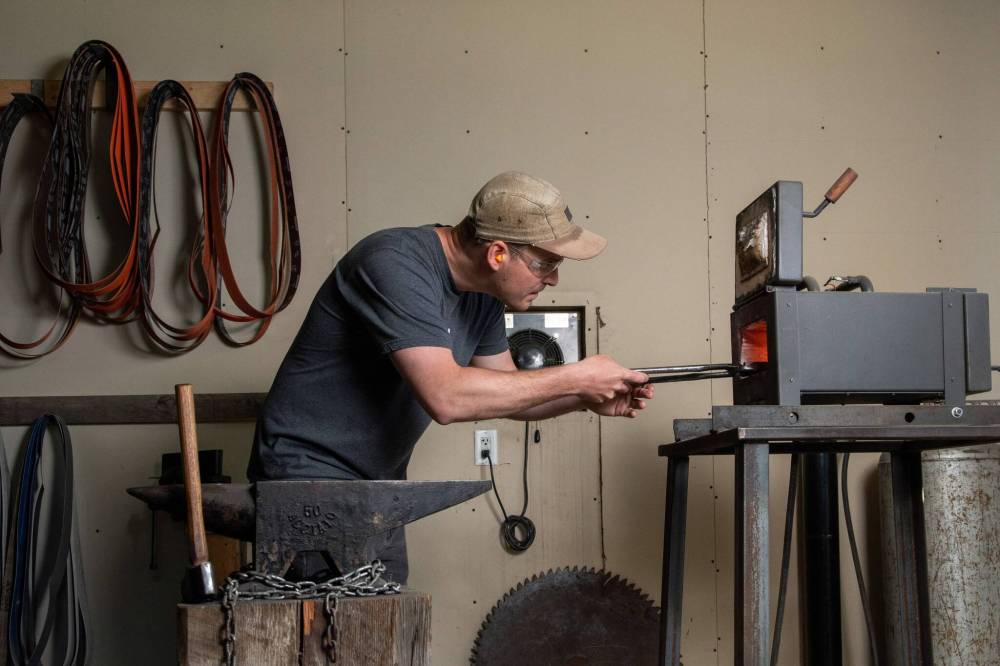 Marc Liss works with his forge and anvil at his workshop in Balmoral where he makes all of his products. (Ethan Cairns / Winnipeg Free Press)