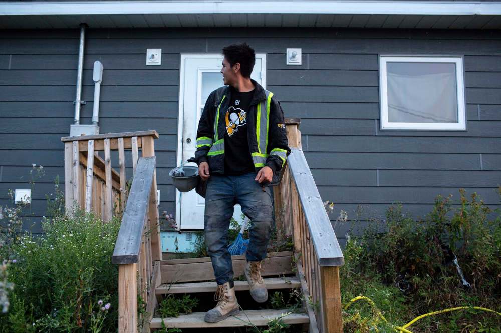 ANDREW RYAN / WINNIPEG FREE PRESS
Fernando Paypompee looks back at his home, just steps away from Freedom Road, on his way to work on the morning of Aug. 26.