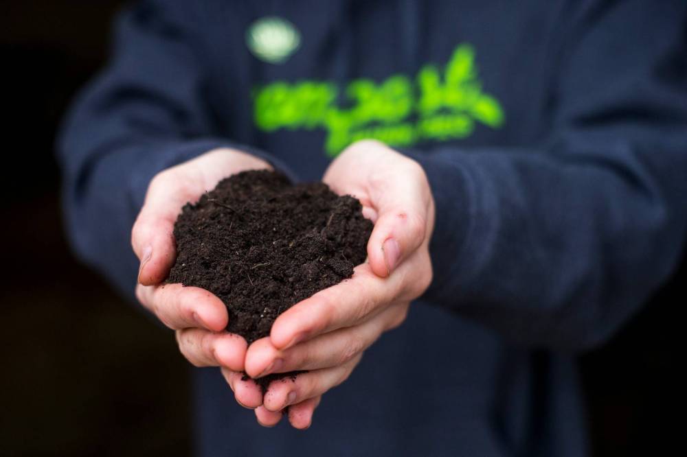 MIKAELA MACKENZIE / WINNIPEG FREE PRESS
Alyssa Wolfe, compost courier, holds up a handful of the tester compost that they’re sending out to gauge interest and sale viability at Compost Winnipeg in Winnipeg.
