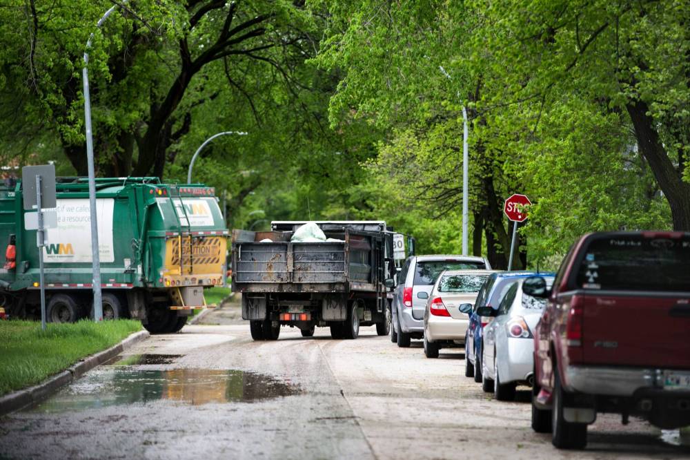 MIKAELA MACKENZIE / WINNIPEG FREE PRESS
A Compost Winnipeg truck navigates residential streets (behind a dump truck) in Winnipeg.