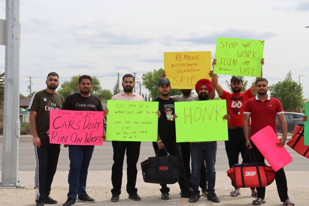 BRYCE HUNT / WINNIPEG FREE PRESS
Protesters hold signs on a Regent Avenue sidewalk to strike against food delivery services. The drivers are requesting a pay raise from $7 to $9 per delivery.