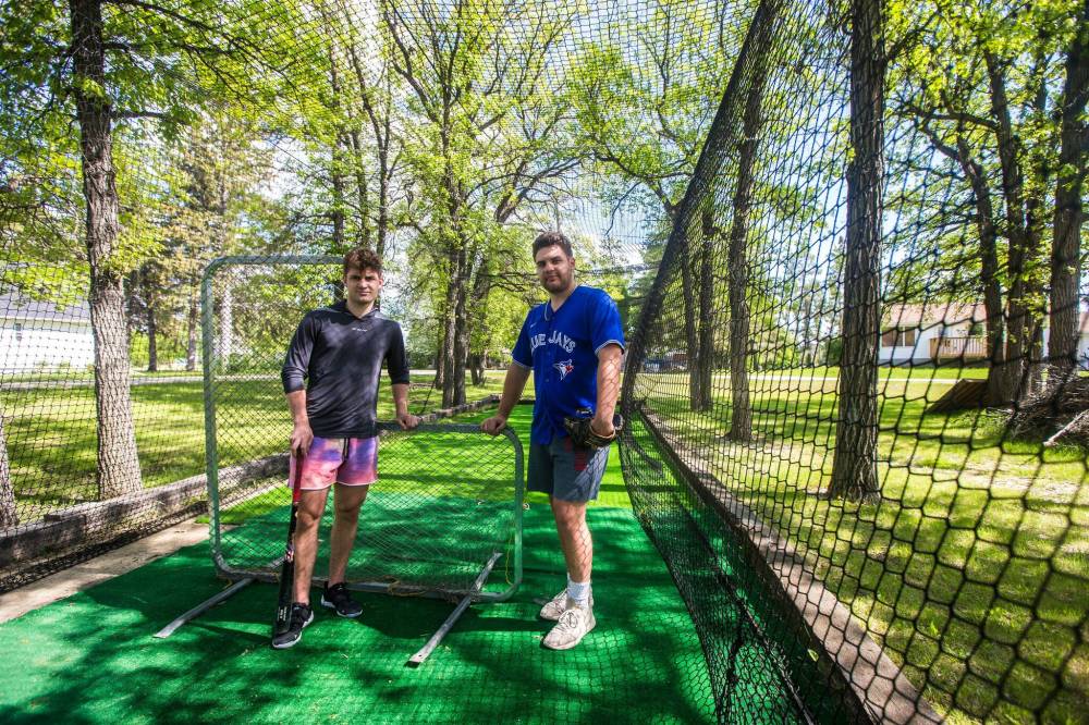 MIKAELA MACKENZIE / WINNIPEG FREE PRESS
Denton Mateychuk (left) and his older brother, Maddux, in their backyard batting cage.