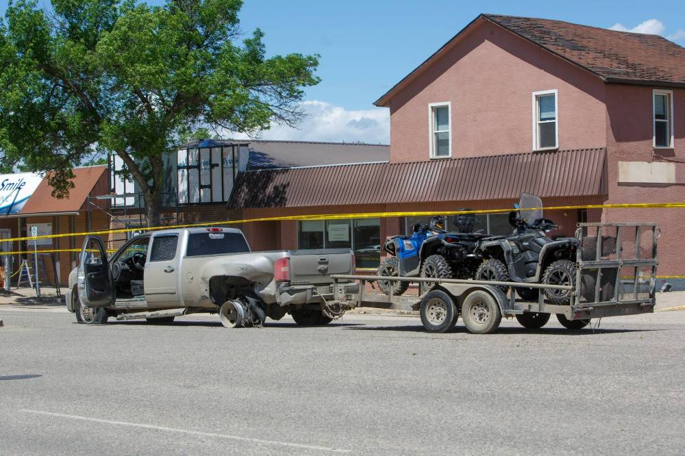 MIKE DEAL / WINNIPEG FREE PRESS
A pickup truck and a trailer with ATVs sits in the middle of Saskatchewan Avenue East in Portage la Prairie on Wednesday. The driver was shot by an officer after allegedly driving at him.
