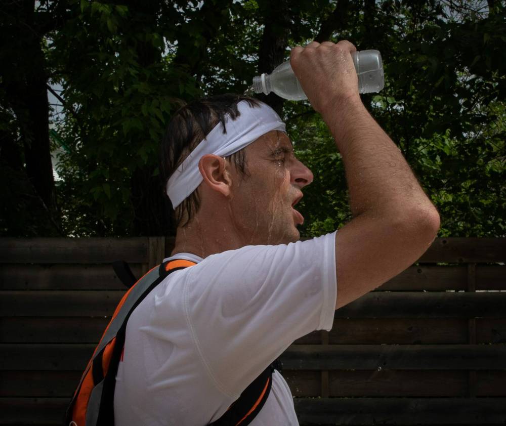 A marathoner pours water on their face during the last few kilometres of the Manitoba Marathon on Sunday near Pembina Highway. (Jessica Lee / Winnipeg Free Press)