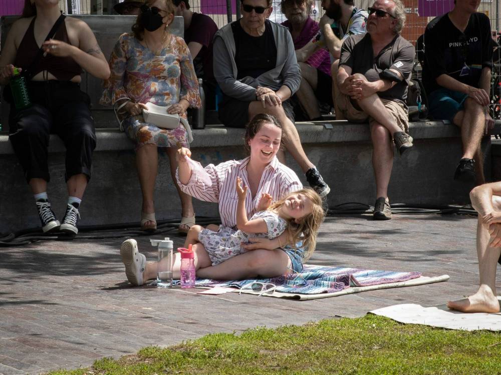 Emily Kidd and her daughter Joan, 3, fan themselves at the Winnipeg Jazz Festival on Sunday. (Jessica Lee / Winnipeg Free Press)