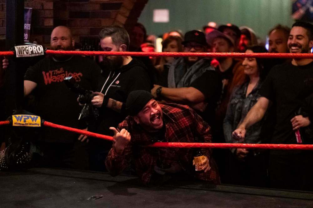 A fan leans into the ring to cheer during a fight.