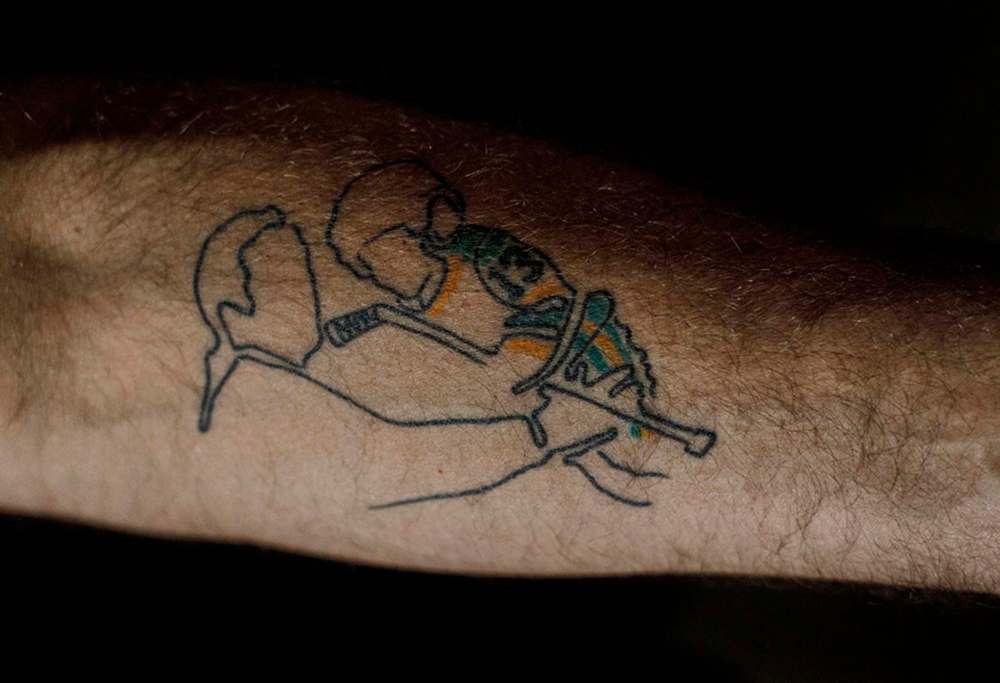 Former NHLer Chris Joseph’s tattoo recreates a favourite photo — Joseph holding his two-year-old son Jaxon at a Canucks family skate. Jaxon was one of the 16 who died in the Humboldt Broncos tragedy. (Jason Franson / The Canadian Press)