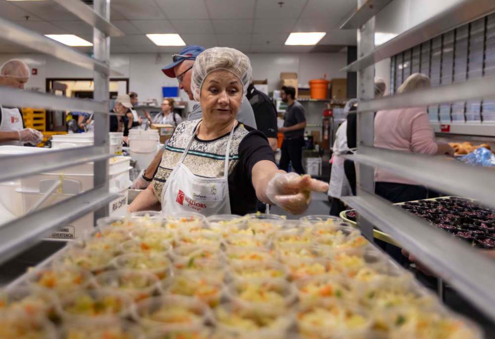 Volunteers help prepare and serve the annual Easter meal hosted by Siloam Mission on Monday.