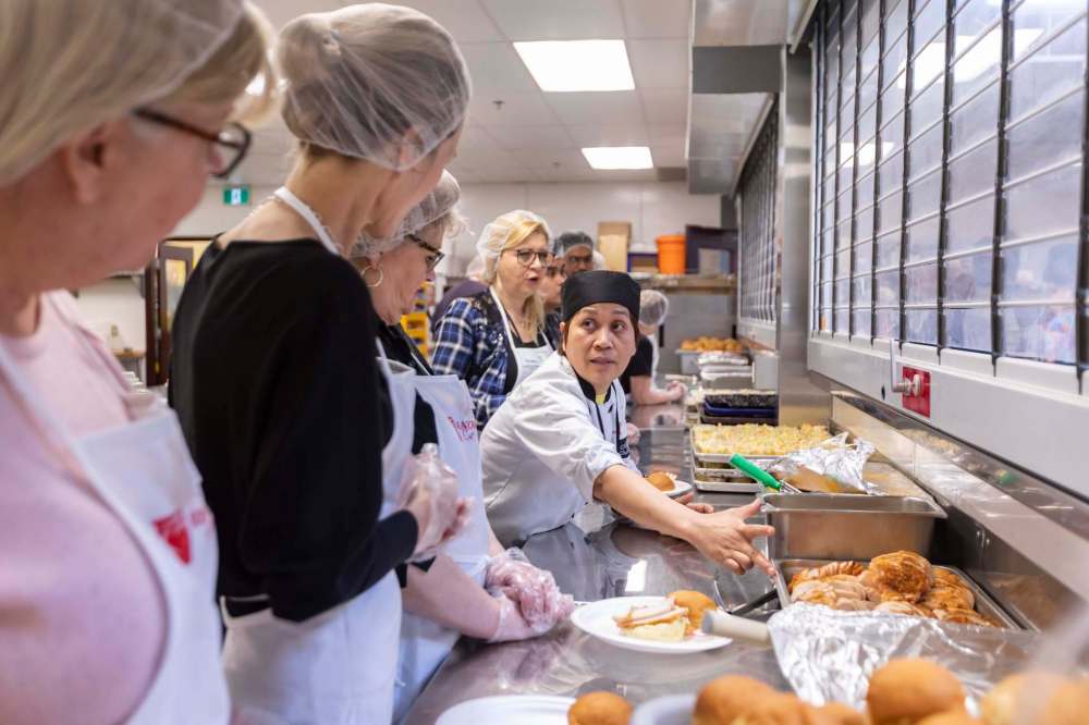 Volunteers help prepare and serve the annual Easter meal hosted by Siloam Mission on Monday.
