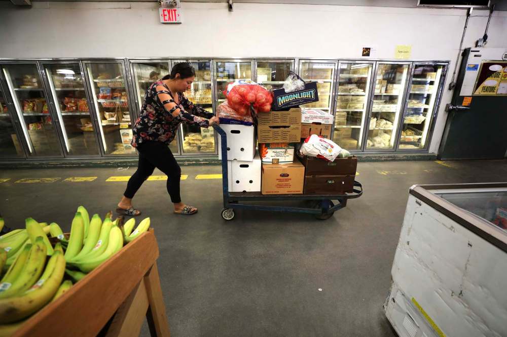 McDonald heads out of Sobeys with a dolly full of boxes of fresh food.