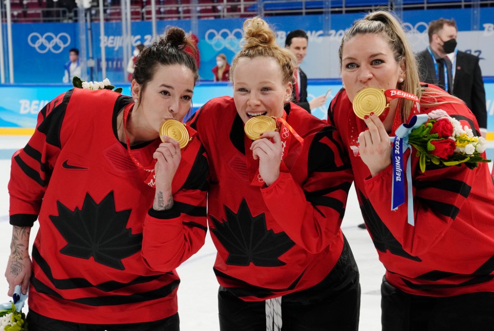 CP
Team Canada's Melodie Daoust (15), Sarah Fillier (10) and Natalie Spooner (24) celebrate with their gold medals after defeating the United States in women's hockey gold medal game action at the 2022 Winter Olympics in Beijing on Thursday, Feb. 17, 2022. (Ryan Remiorz / The Canadian Press)