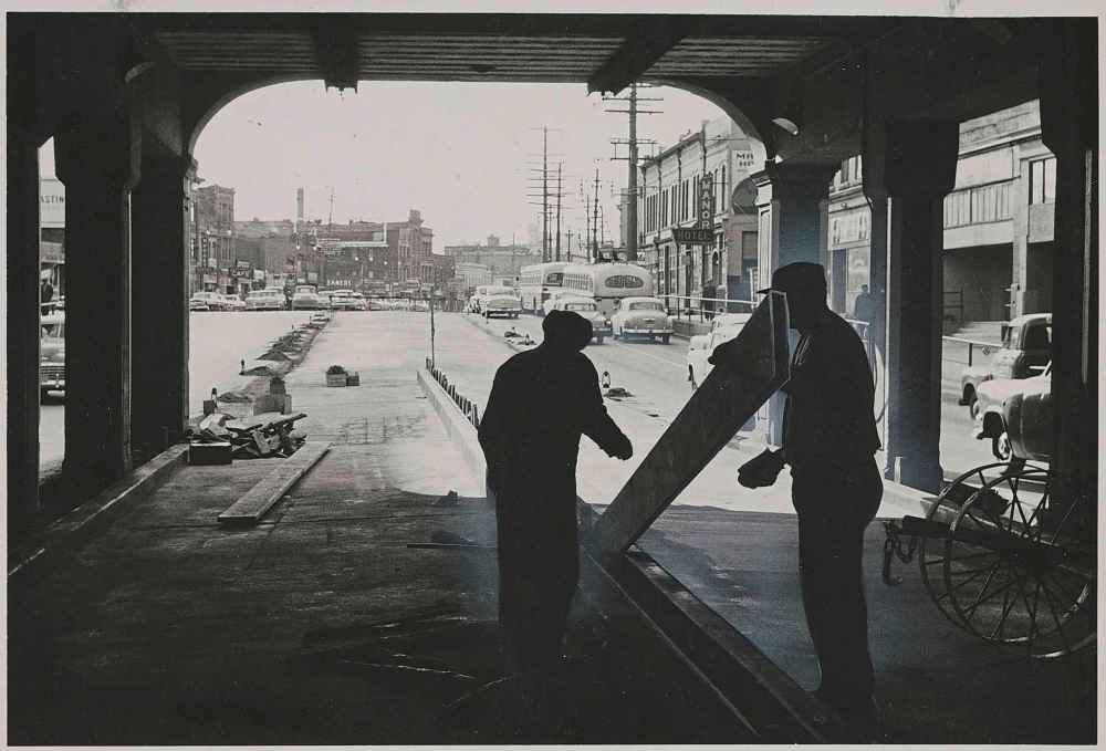 WINNIPEG FREE PRESS FILES
Pillars of the north Main Street subway, under the C.P.R. tracks, form a frame for two workers as they put the finishing touches on a section of a paving job expected to greatly ease a traffic bottleneck in October 1955. The pavement, which replaced the streetcar tracks, provided two additional lanes for automobiles.