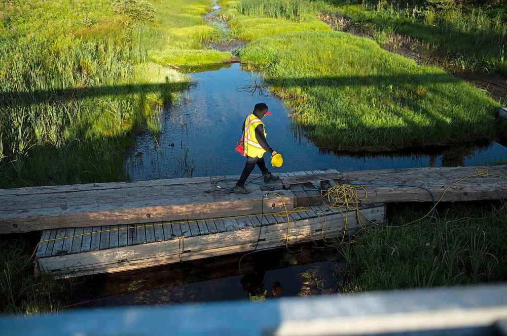 ANDREW RYAN / WINNIPEG FREE PRESS
Rock truck driver and Shoal Lake 39 resident Davidson walks across the Winnipeg aquaduct which pumps water from Shoal Lake to the city towards Freedom Road.
