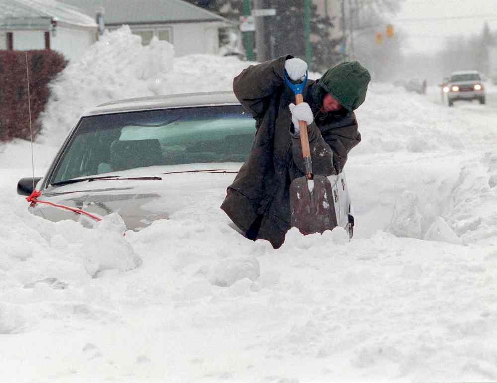 The snowfall was not merely deep - it was lead-heavy. It would melt into millions of cubic feet of water. Plaridel Orcullo digs out on Mountain Avenue after the storm. (Wayne Glowacki / Winnipeg Free Press files)