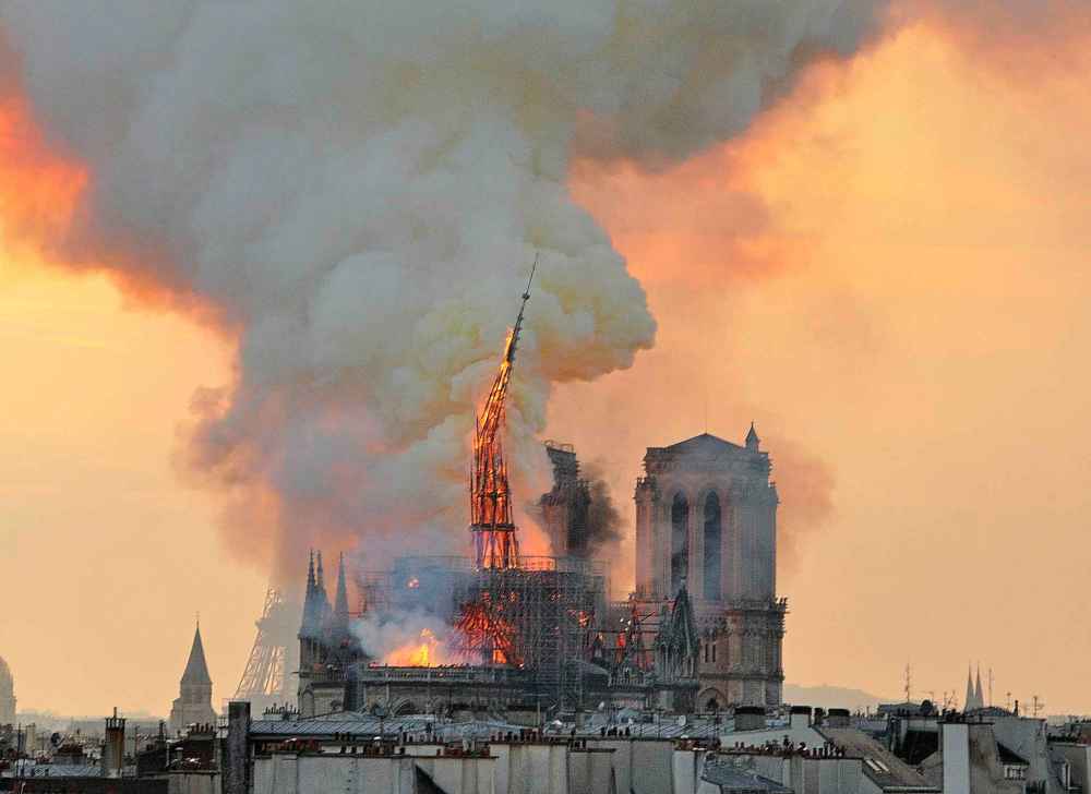 The spire, in flames, topples. (Thierry Mallet / The Associated Press)