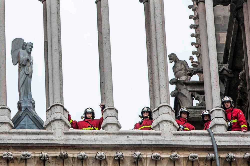 Fire fighters are seen in a tower of Notre Dame cathedral. (Christophe Petit Tesson / The Associated Press)