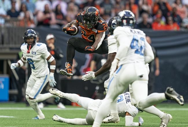 BC Lions' James Butler jumps over the tackle of Toronto Argonauts' Royce Metchie during first half of CFL football action in Vancouver, B.C., Saturday, June 25, 2022. THE CANADIAN PRESS/Rich Lam