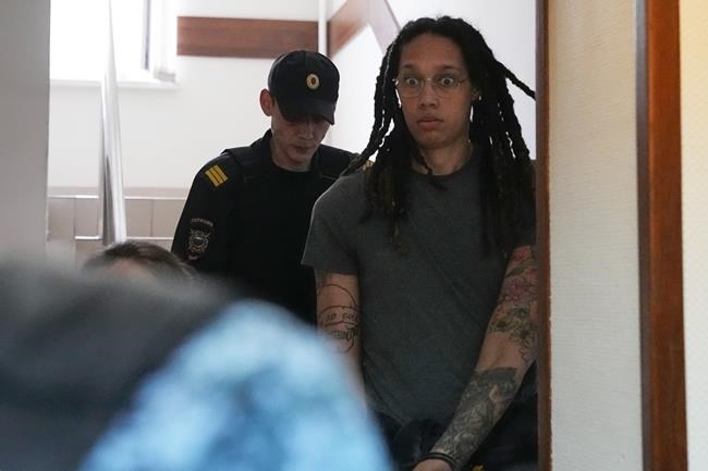 WNBA star and two-time Olympic gold medalist Brittney Griner is escorted to a courtroom for a hearing, in Khimki just outside Moscow, Russia, Monday, June 27, 2022. More than four months after she was arrested at a Moscow airport for cannabis possession, American basketball star Brittney Griner is to appear in court Monday for a preliminary hearing ahead of her trial. (AP Photo/Alexander Zemlianichenko)