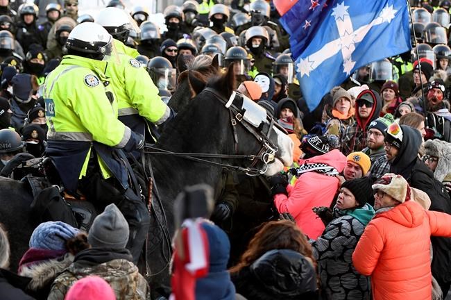 Protesters react as Toronto Police mounted unit charge to disperse as police take action to put an end to a protest, which started in opposition to mandatory COVID-19 vaccine mandates and grew into a broader anti-government demonstration and occupation, in Ottawa, Friday, Feb. 18, 2022. The commissioner of the inquiry examining Ottawa's use of the Emergencies Act to bring an end to the so-called