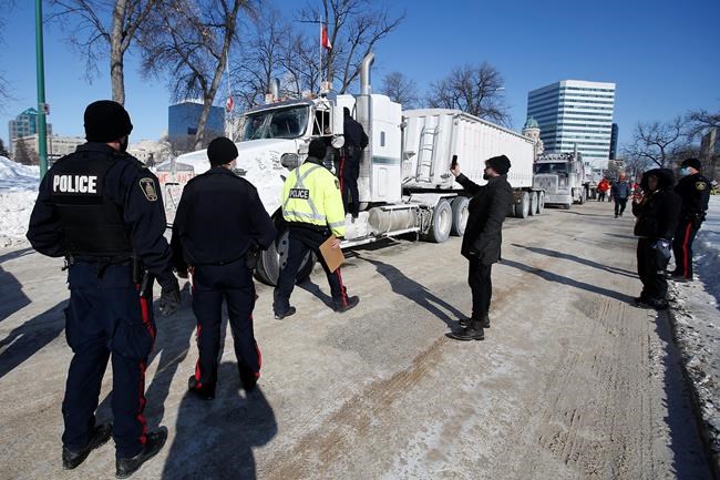 Winnipeg police talk to the lead driver in a convoy of COVID-19 mandate protest trucks as they head home Wednesday, February 23, 2022. Protesters opposing COVID-19 restrictions who blocked off streets in downtown Winnipeg earlier this year cost police nearly half a million dollars.THE CANADIAN PRESS/John Woods