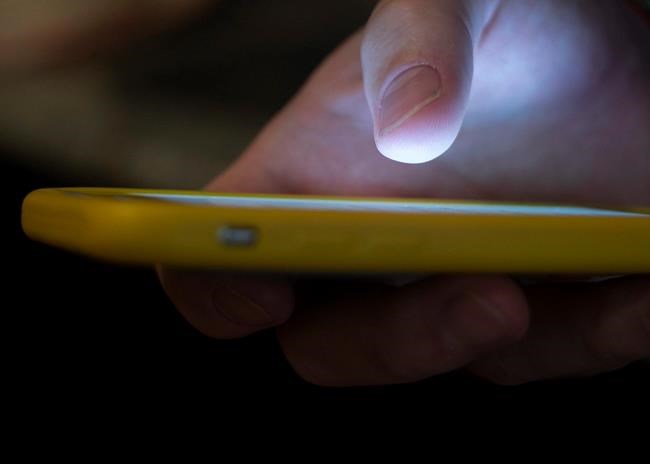 In this Aug. 11, 2019, file photo, a man uses a cell phone in New Orleans. Pressure is mounting for Canada to establish a three-digit suicide crisis hotline, similar to the one implemented by the United States this weekend. THE CANADIAN PRESS/AP/Jenny Kane