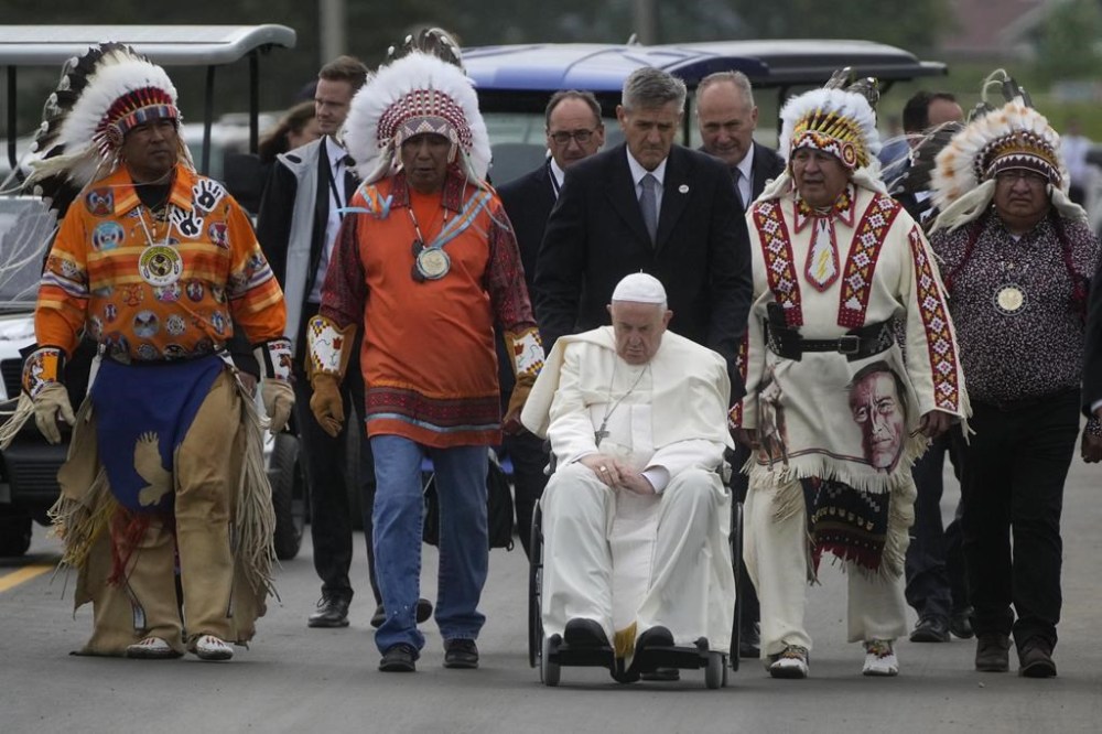 Pope Francis leaves with Indigenous peoples after praying in a cemetery at the former residential school, in Maskwacis, near Edmonton, Canada, Monday, July 25, 2022. Pope Francis begins a