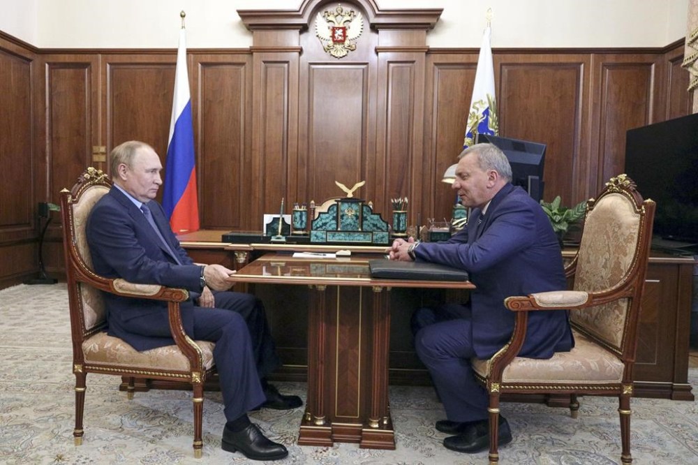 Russian President Vladimir Putin, left, listens to Yuri Borisov, the new CEO of the Russian State Space Corporation