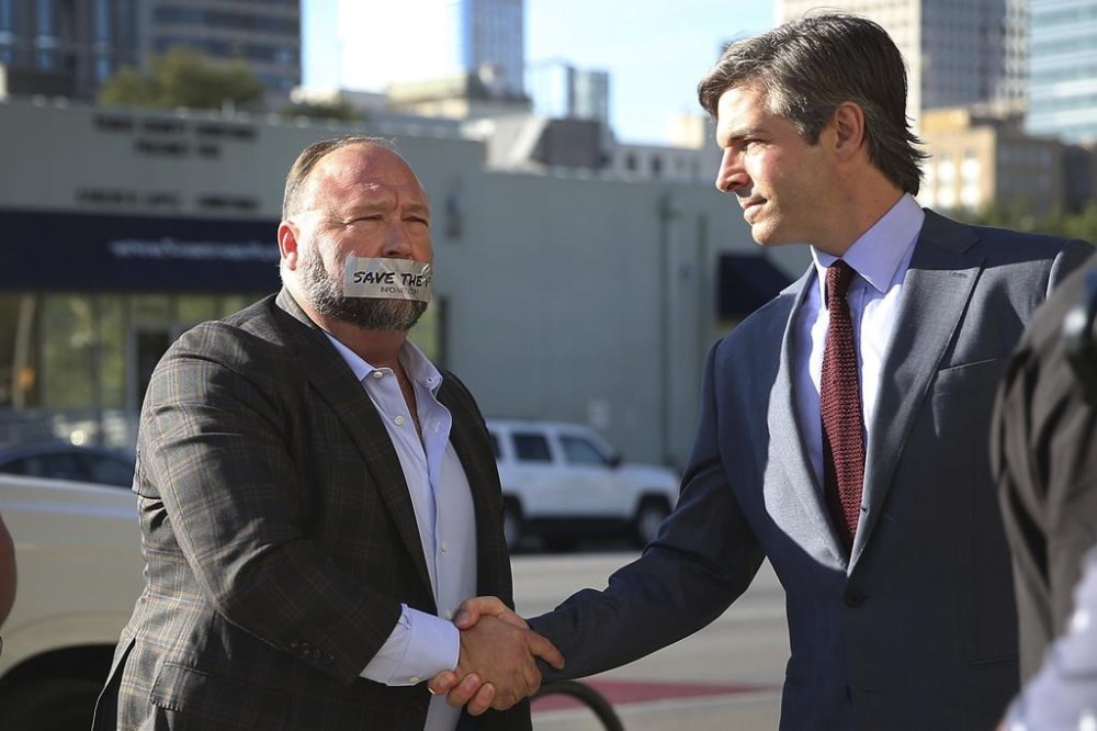 Alex Jones arrives at the Travis County Courthouse in Austin, Texas, Tuesday, July 26, 2022, with a piece of tape over his mouth that reads