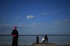Pope Francis gets water from the lake after blessing it during the annual pilgrimage event in Lac Ste. Anne, Alta., Tuesday, July 26, 2022. THE CANADIAN PRESS/Nathan Denette